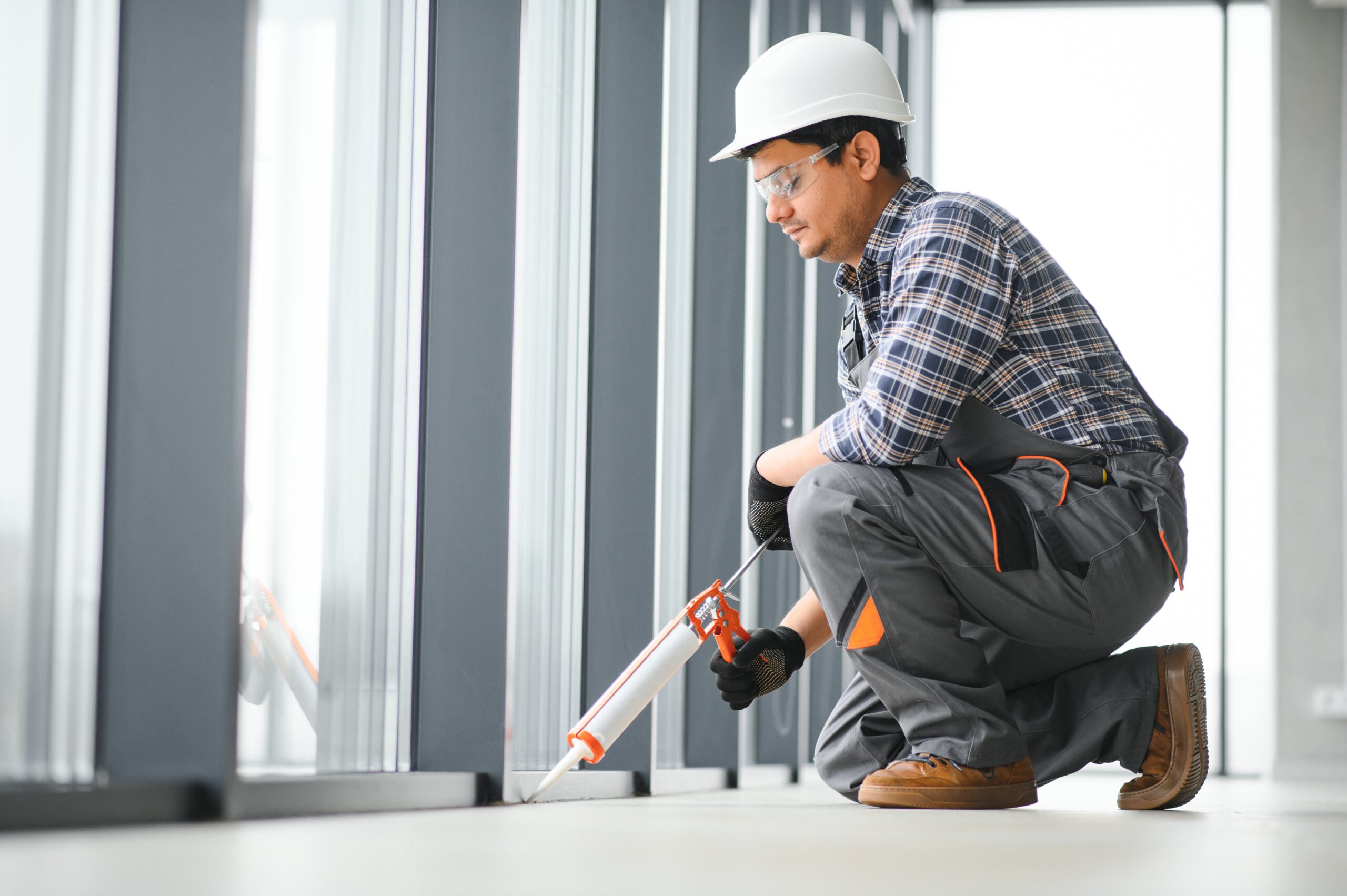 The worker installs a window frame in the room.